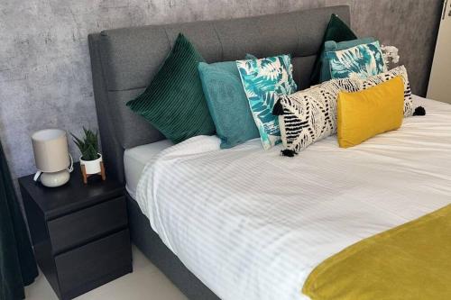 拉斯阿尔卡麦Beach Dream - a luxury 1 bedroom apartment with direct beach access的床上有色彩缤纷的枕头