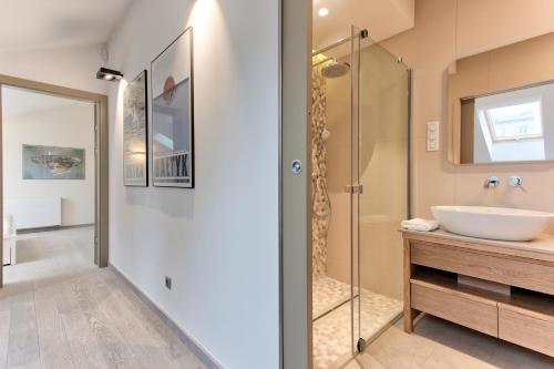 克拉科夫Tyzenhauz Villas的一间带水槽和玻璃淋浴的浴室