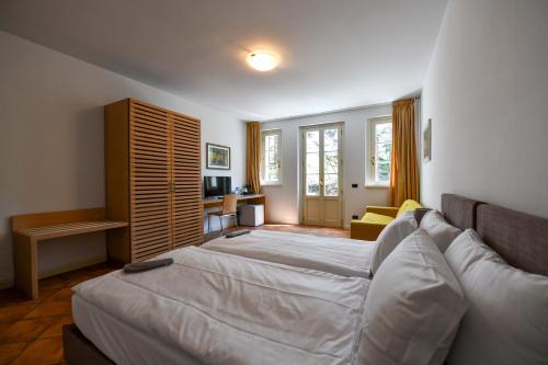 坎诺比奥Aquazzurra Resort & Aparthotel的酒店客房,设有两张床和一张沙发