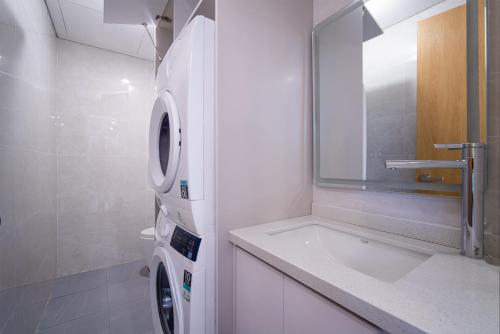 岘港HSuites Riverside Hotel and Apartment的一间带洗衣机和水槽的浴室