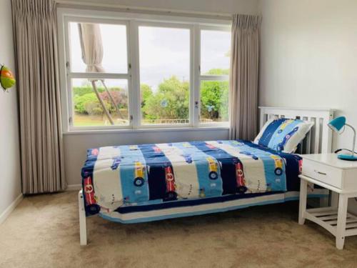 KumeuBesties West Auckland的一间卧室设有一张床和一个窗口