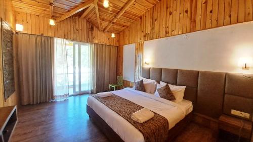 瑞诗凯诗Qcent Woods Resort & Spa, Rishikesh的一间带一张大床的卧室,位于带木墙的房间