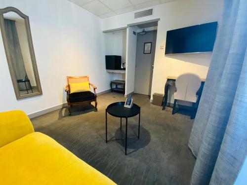 阿尔勒Brit Hotel Acacias的客厅配有黄色的沙发和椅子