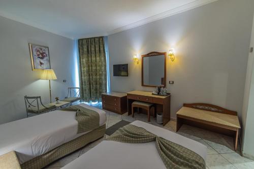 赫尔格达Dexon Roma Hotel的酒店客房,设有两张床和镜子
