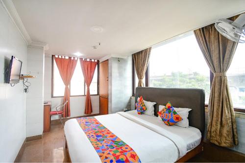 SaluaFabHotel Raj Darbar的一间卧室设有一张大床和一个大窗户