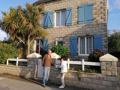 GoulvenL'air Breton的站在房子前面的男人和女人