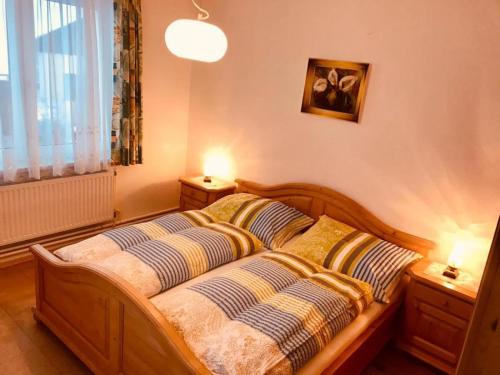 BrauneggBraunegger-Hof Gasthof Mayer的一间卧室配有一张带两个枕头的木床
