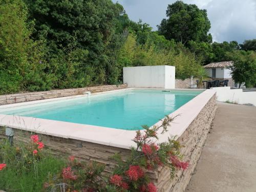 波尔蒂乔CHAMBRE EVASION VUE EXCEPTIONNELLE PORTICCIO的游泳池四周环绕着石墙
