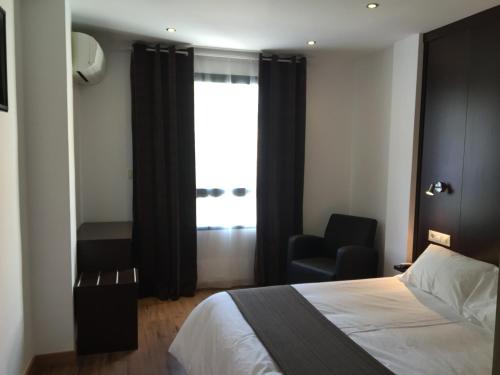 比利亚罗夫莱多卡斯蒂洛酒店的卧室配有床、椅子和窗户。