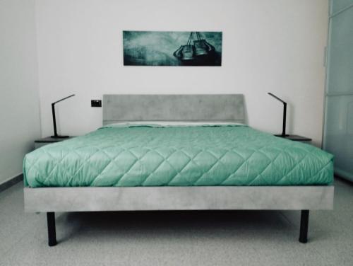 迪亚诺卡斯泰洛Casa Relax Diano Castello的一间卧室配有一张带绿床罩的床