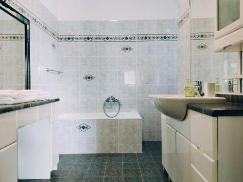 迪亚诺卡斯泰洛Casa Relax Diano Castello的白色的浴室设有浴缸和水槽。