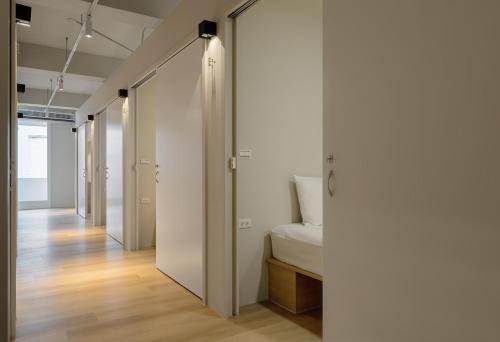 彰化市Timios Inn 提米好旅的一间拥有白色墙壁的走廊和一张位于客房内的床