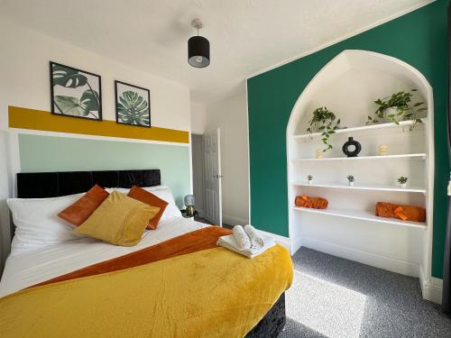 利物浦Air Host and Stay - Phillimore - sleeps 9, mins from city free parking的一间卧室配有一张带绿色和白色墙壁的床