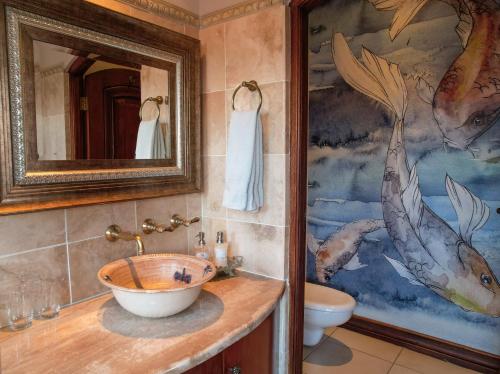 哈里史密斯野生马小屋酒店的一间带水槽的浴室和墙上的绘画