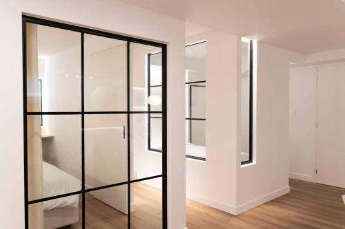卡利斯托斯Underground Luxury Living的白色客房的玻璃衣柜,铺有木地板