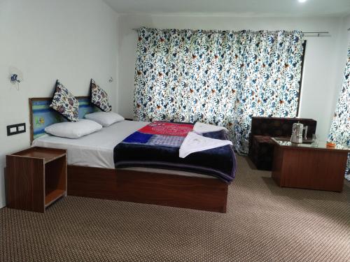 帕哈尔加姆Tip Top Pahalgam的卧室配有床、椅子和窗户。