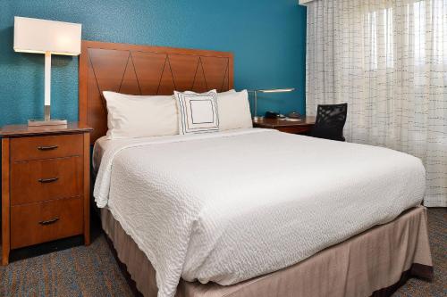 奥罗拉Residence Inn by Marriott Denver Airport at Gateway Park的卧室配有白色大床和床头柜。