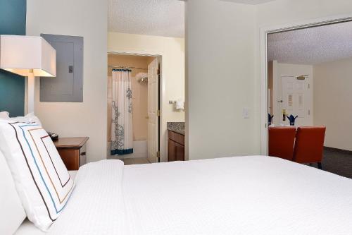 奥罗拉Residence Inn by Marriott Denver Airport at Gateway Park的一间带白色床的卧室和一间浴室