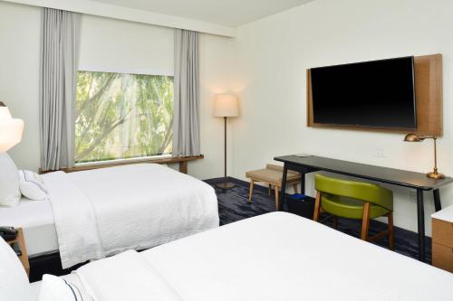 夏洛特Fairfield Inn & Suites by Marriott Charlotte University Research Park的酒店客房设有两张床和一张书桌及电视