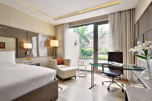 孟买JW Marriott Mumbai Sahar Airport的配有一张床和一张书桌的酒店客房