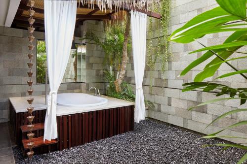 勒吉安巴厘岛勒吉安万豪酒店的设有带浴缸和淋浴的浴室。
