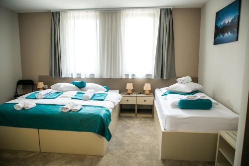 苏博蒂察Garni Hotel IMPERIUM Subotica的酒店客房,配有两张带毛巾的床