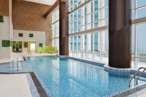 多哈Element by Westin City Center Doha的一座大型游泳池,位于一座带窗户的建筑内