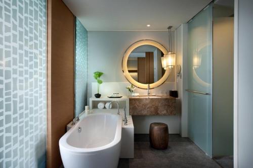 港生Rayong Marriott Resort & Spa的带浴缸、水槽和镜子的浴室