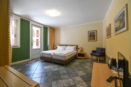 坎诺比奥Aquazzurra Resort & Aparthotel的一间卧室配有一张床和一把椅子