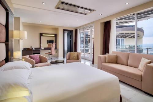 坎帕拉Protea Hotel by Marriott Kampala Skyz的一间带大床的卧室和一间客厅