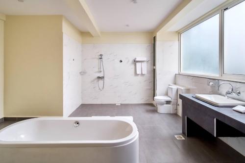 坎帕拉Protea Hotel by Marriott Kampala Skyz的带浴缸、卫生间和盥洗盆的浴室