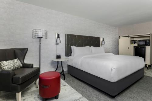 阿马里洛Four Points by Sheraton Amarillo Central的配有一张床和一把椅子的酒店客房