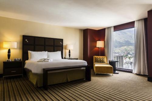 加拉加斯卡拉卡斯拉卡斯提亚万丽酒店的酒店的客房 - 带一张床、椅子和窗户