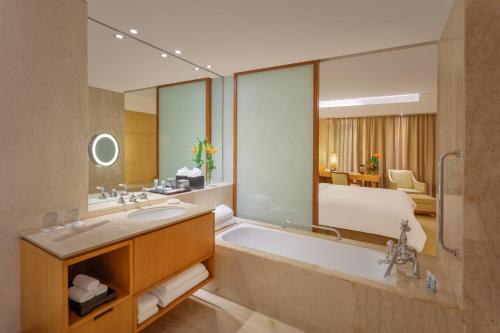 加尔各答ITC Sonar, a Luxury Collection Hotel, Kolkata的一间带浴缸的浴室和一张位于客房内的床