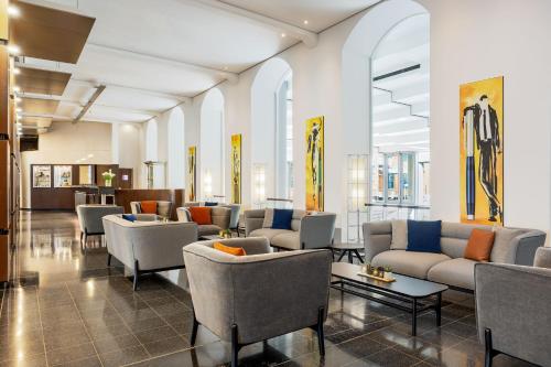 汉诺威汉诺威佩里坎喜来登酒店的大楼内一个带沙发和椅子的大堂