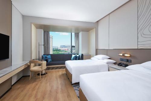 长春长春保利万怡酒店的酒店客房设有两张床和电视。