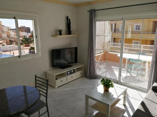 阿德耶Apartamento Costa Adeje - Orlando Complex的客厅配有平面电视和桌子。