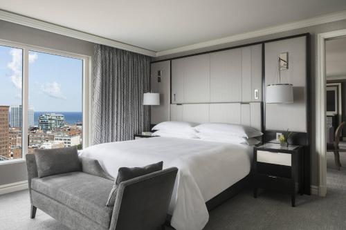 克利夫兰克利夫兰丽思卡尔顿酒店的卧室配有床、椅子和窗户。