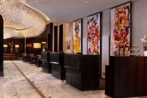 美因河畔法兰克福法兰克福朱美拉酒店的酒店大堂设有带椅子和绘画的酒吧