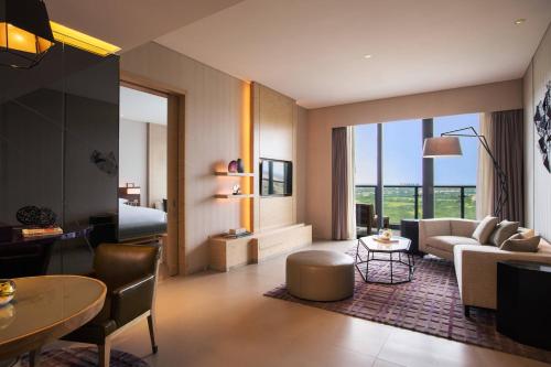 海口海口万丽酒店 的客厅配有沙发和桌子