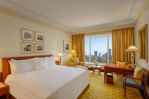 孟买ITC Grand Central, a Luxury Collection Hotel, Mumbai的配有一张床、一张书桌和一扇窗户的酒店客房