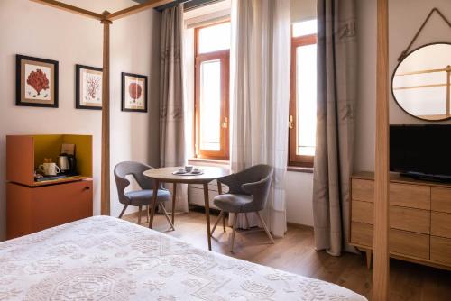 阿尔盖罗Sella&Mosca Casa Villamarina的卧室配有一张床和一张桌子及椅子