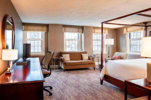 剑桥Sheraton Commander Hotel的酒店客房,配有一张床、一张桌子和椅子