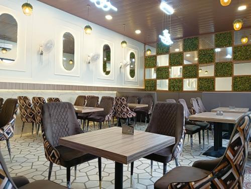 范兰德凡The Govindam Resort的一间带桌椅和镜子的用餐室