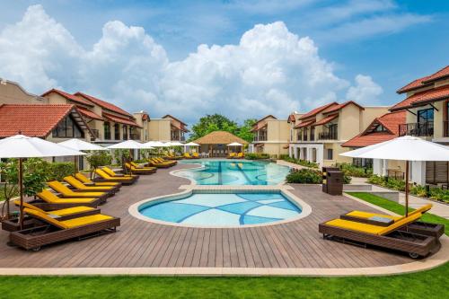 比纳里姆Fairfield by Marriott Goa Benaulim的度假村的游泳池配有躺椅和遮阳伞