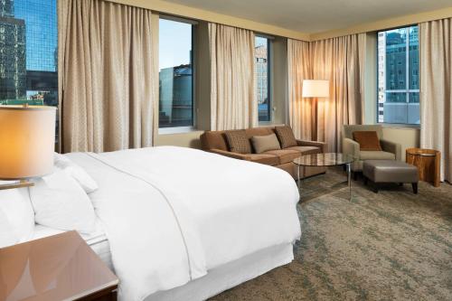 明尼阿波利斯明尼阿波利斯威斯丁酒店的一间带白色大床的卧室和一间客厅