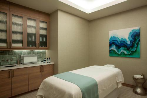 萨拉索塔威斯汀萨拉索塔酒店的一间卧室配有一张床、一台电视和橱柜