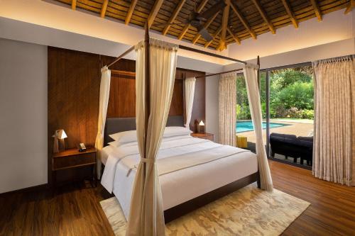 马哈巴利普拉姆Sheraton Grand Chennai Resort & Spa的一间卧室设有一张床和一个游泳池