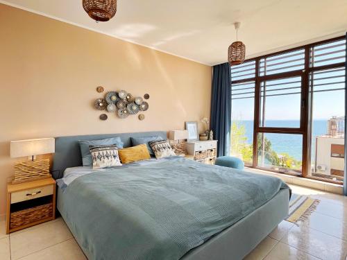 圣弗拉斯Dolce Vita Blue Boho, Premium Apartment with seaview的一间卧室设有蓝色的床和大窗户