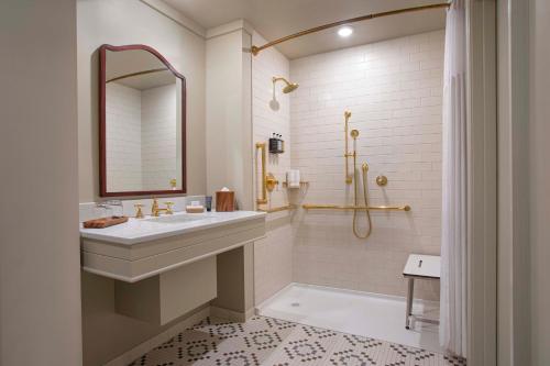 普莱西德湖Grand Adirondack Hotel, Lake Placid, a Tribute Portfolio Hotel的白色的浴室设有水槽和淋浴。